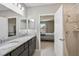 Well-appointed bathroom with granite counters, double sinks, and a door leading to the bedroom at 4523 Birdsong Dr, Palmetto, FL 34221