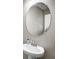 Close-up of a pedestal sink in the bathroom with a stylish faucet and oval mirror at 4523 Birdsong Dr, Palmetto, FL 34221