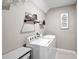 Functional laundry room with modern washer and dryer, shelving, and decor at 4523 Birdsong Dr, Palmetto, FL 34221