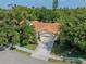 Aerial view of a well-maintained home with tile roof, lush landscaping, and long driveway on a sunny day at 4885 Tamarack Trl, Venice, FL 34293