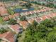 An aerial view shows a property with an orange tile roof, surrounded by lush trees, with a property outline at 4885 Tamarack Trl, Venice, FL 34293
