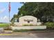 Neighborhood entrance sign with manicured landscaping, American flag, and brick-paved street at 4885 Tamarack Trl, Venice, FL 34293
