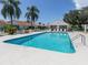 Community swimming pool with lounge chairs and mature landscaping, perfect for summer days at 4885 Tamarack Trl, Venice, FL 34293