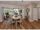 Bright dining area with hardwood floors, modern light fixture, and sliding doors to a screened-in patio at 4885 Tamarack Trl, Venice, FL 34293