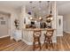 Open kitchen with a breakfast bar featuring rattan stools, granite countertops, and pendant lighting at 4885 Tamarack Trl, Venice, FL 34293