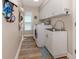 Well-equipped laundry room with wood floors, front-load washer/dryer and ample storage cabinets at 4885 Tamarack Trl, Venice, FL 34293