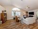 Bright living room featuring wood floors, vaulted ceiling, white sofas, and a large window at 4885 Tamarack Trl, Venice, FL 34293