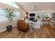 Inviting living room features hardwood floors, vaulted ceiling, large windows, and cozy seating area at 4885 Tamarack Trl, Venice, FL 34293