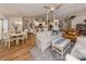 Open-concept living area featuring wood floors, comfortable seating, and access to kitchen and dining at 4885 Tamarack Trl, Venice, FL 34293