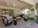 Covered patio featuring comfortable seating, ceiling fan, and views of the lush backyard at 4885 Tamarack Trl, Venice, FL 34293