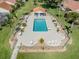 Community pool with lounge chairs, tables, and a covered area for residents to relax at 4885 Tamarack Trl, Venice, FL 34293