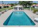 Community pool with clear blue water surrounded by lounge chairs and well-maintained landscaping offers residents a relaxing oasis at 4885 Tamarack Trl, Venice, FL 34293