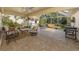 Expansive screened patio offers lounge seating, dining area, grill, and a serene view of the lush landscaping at 4885 Tamarack Trl, Venice, FL 34293