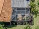 This aerial shot showcases a screen-enclosed patio with a table and chairs, surrounded by vibrant plants at 4885 Tamarack Trl, Venice, FL 34293