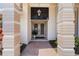 Elegant front entrance featuring decorative columns, double doors, and beautiful landscaping at 511 Governors Green Dr, Venice, FL 34293