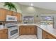 Kitchen with oak cabinets, white countertops, and pool views from the windows at 511 Governors Green Dr, Venice, FL 34293
