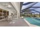 Screened-in pool and spa, adjacent to an outdoor patio with a seating area at 511 Governors Green Dr, Venice, FL 34293