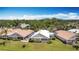 Aerial view of a home with a white roof, lush green lawn, and mature trees at 542 Clubside Cir # 20, Venice, FL 34293