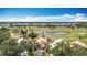 Overhead view of golf course community with a serene lake and well-manicured grounds and residential buildings at 542 Clubside Cir # 20, Venice, FL 34293