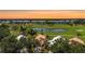 Scenic aerial view of the community, showcasing lush green golf course and community buildings at sunset at 542 Clubside Cir # 20, Venice, FL 34293