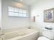 Cozy bathroom featuring a soaking tub, a toilet, and a window at 542 Clubside Cir # 20, Venice, FL 34293