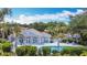 Beautiful community pool with palm trees, lush green landscaping, and ample seating for relaxation at 542 Clubside Cir # 20, Venice, FL 34293