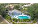 Gorgeous aerial view of a blue community pool with chairs and a patio surrounded by lush landscaping and palm trees at 542 Clubside Cir # 20, Venice, FL 34293