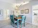Cozy dining area with a rustic wooden table, blue chairs, and views into other living spaces at 542 Clubside Cir # 20, Venice, FL 34293