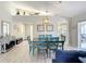 Stylish dining area with a unique chandelier, blue chairs, and view of living room and kitchen at 542 Clubside Cir # 20, Venice, FL 34293