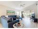 Bright living room with vaulted ceiling, comfortable blue sectional sofa, and sliding doors to lanai at 542 Clubside Cir # 20, Venice, FL 34293