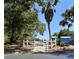Pathway through community grounds with white picket fence, lush trees and landscaping, with blue recreation building at 542 Clubside Cir # 20, Venice, FL 34293