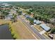 Aerial view of a neighborhood with tree lined streets, houses with green yards, and a small pond at 5457 Talbrook Rd, North Port, FL 34287