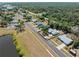 Aerial view of a neighborhood with tree lined streets, houses with green yards, and a small pond at 5457 Talbrook Rd, North Port, FL 34287