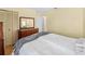 Cozy bedroom showcases hardwood floors, a dresser with a mirror, and closet with paneled doors at 5457 Talbrook Rd, North Port, FL 34287