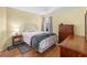 Bright bedroom features a full bed, hardwood floors, and a wooden dresser with an adjacent window at 5457 Talbrook Rd, North Port, FL 34287