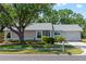 Charming single-story home with a well-manicured front yard, mature landscaping, and attached garage at 5457 Talbrook Rd, North Port, FL 34287