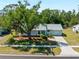 Charming home with a large shade tree, green lawn, and mature landscaping, offering serene curb appeal at 5457 Talbrook Rd, North Port, FL 34287