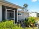Charming home featuring a screened entry, a well maintained lawn, and lush tropical landscaping at 5457 Talbrook Rd, North Port, FL 34287