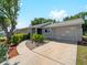 Well-maintained home featuring lush landscaping, a wide driveway, and a two-car garage at 5457 Talbrook Rd, North Port, FL 34287