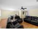 Spacious living room featuring wood floors, ceiling fan, and plush leather seating at 5457 Talbrook Rd, North Port, FL 34287