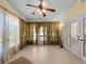 Spacious sunroom with a ceiling fan, lots of windows and french doors, and carpet at 5457 Talbrook Rd, North Port, FL 34287