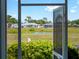 Captured through the front door's screen, this view reveals a serene pond and neighboring houses at 5457 Talbrook Rd, North Port, FL 34287