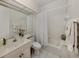 Bright bathroom with a single vanity, bathtub with shower, and white tile flooring at 553 Fallbrook Dr, Venice, FL 34292