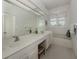 Well-lit bathroom with double sinks, marble countertop, and soaking tub at 553 Fallbrook Dr, Venice, FL 34292