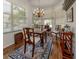 Charming dining area with wooden furniture, area rug, and natural light from large windows at 553 Fallbrook Dr, Venice, FL 34292