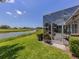 View of screened in lanai with seating overlooking a lake and golf course at 553 Fallbrook Dr, Venice, FL 34292