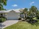 Charming home boasts lush landscaping, a bright white tile roof, and a welcoming two-car garage at 553 Fallbrook Dr, Venice, FL 34292