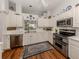 Well-lit kitchen featuring white cabinets, stainless steel appliances, and a patterned area rug at 553 Fallbrook Dr, Venice, FL 34292