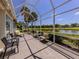 Screened in lanai providing outdoor seating area with a pond and golf course view at 553 Fallbrook Dr, Venice, FL 34292