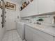 Functional laundry room with white appliances, sink, and ample storage space at 553 Fallbrook Dr, Venice, FL 34292